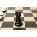 A single black lacquer rook from the 1940s Soviet reproduction set centered on a chessboard.