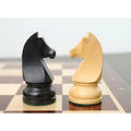 Detailed close-up of an ebonised boxwood knight and a natural boxwood knight facing each other on the board.