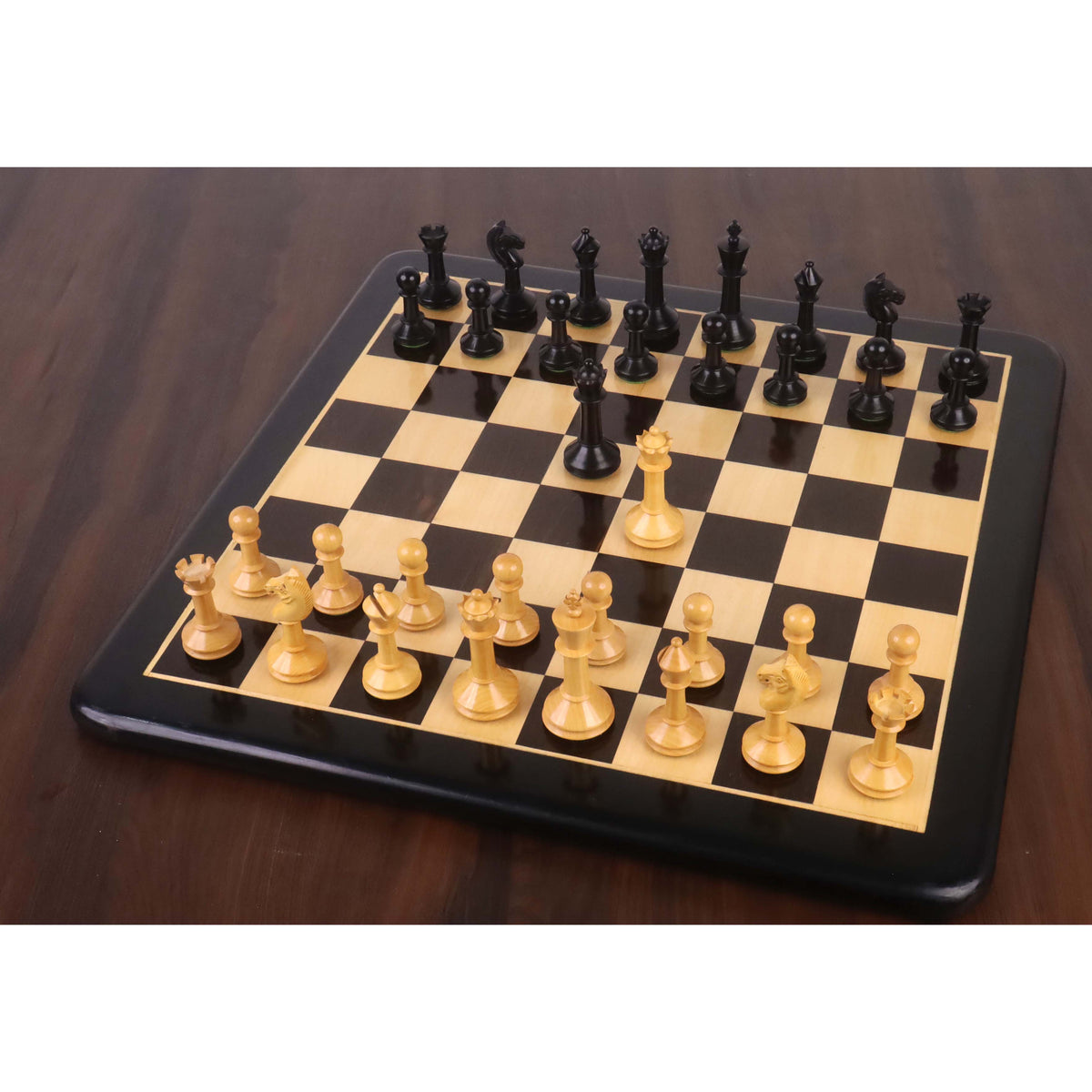 Full setup of the 3.5-inch Monolith miniature chess pieces in ebonised wood and boxwood on a glossy chessboard.