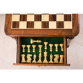 Interior of chess table storage drawer showing organized weighted staunton pieces.