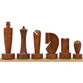 Six minimalist Berliner chess pieces carved from rich golden rosewood lined up on a wooden base.