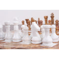 Smooth white marble stone chess pieces arranged in rows on a polished brown onyx chessboard.