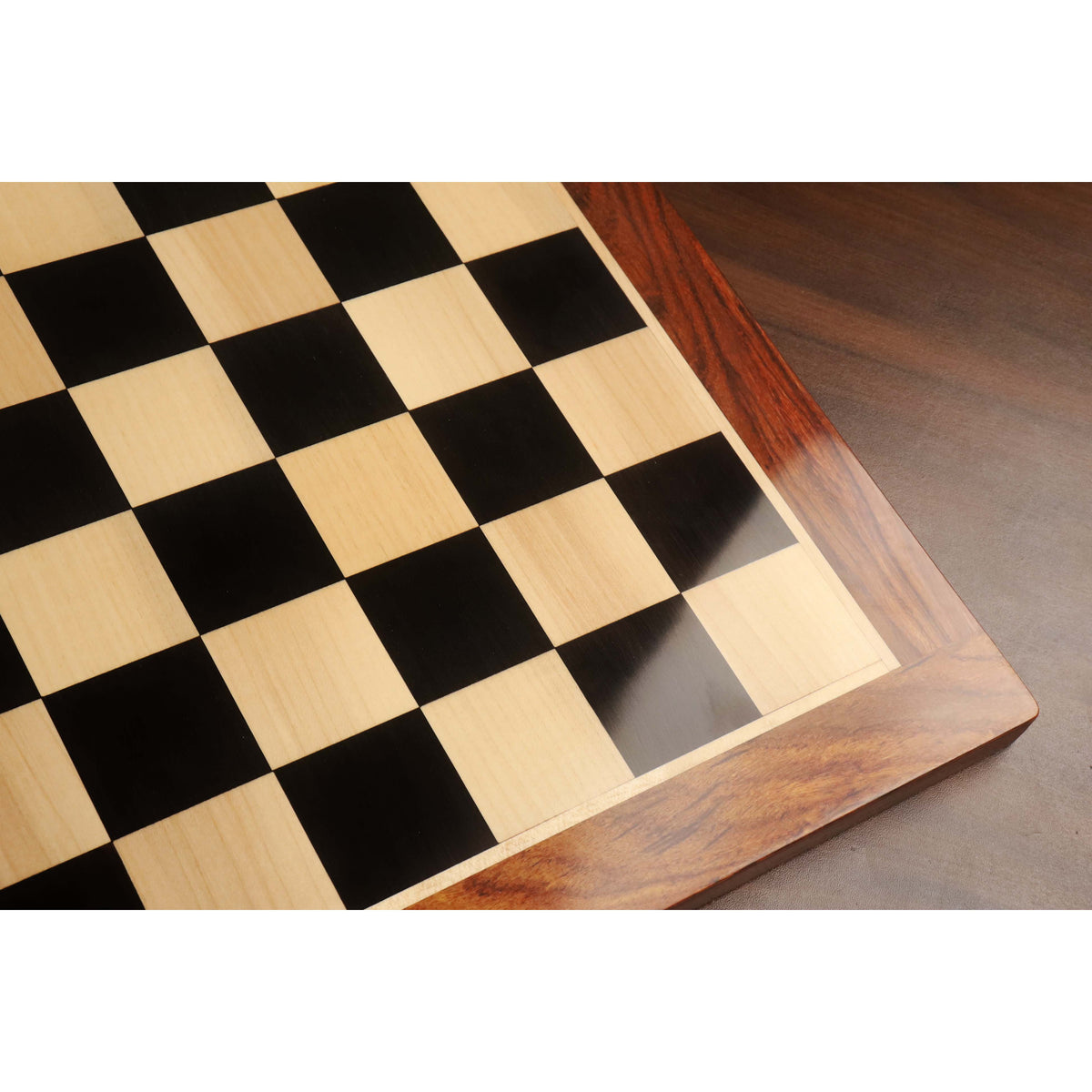High-angle shot showing the smooth matte finish and grain of the Golden Rosewood border on an Ebony and Maple chessboard.