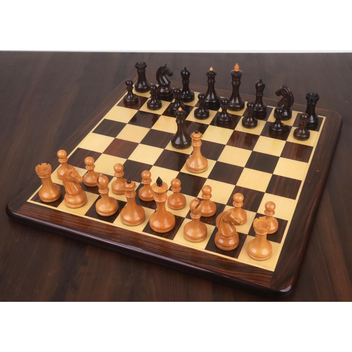 Full setup of the 3.8" Candidates Series minimalist chess set in rosewood and antiqued boxwood on a wooden chessboard.