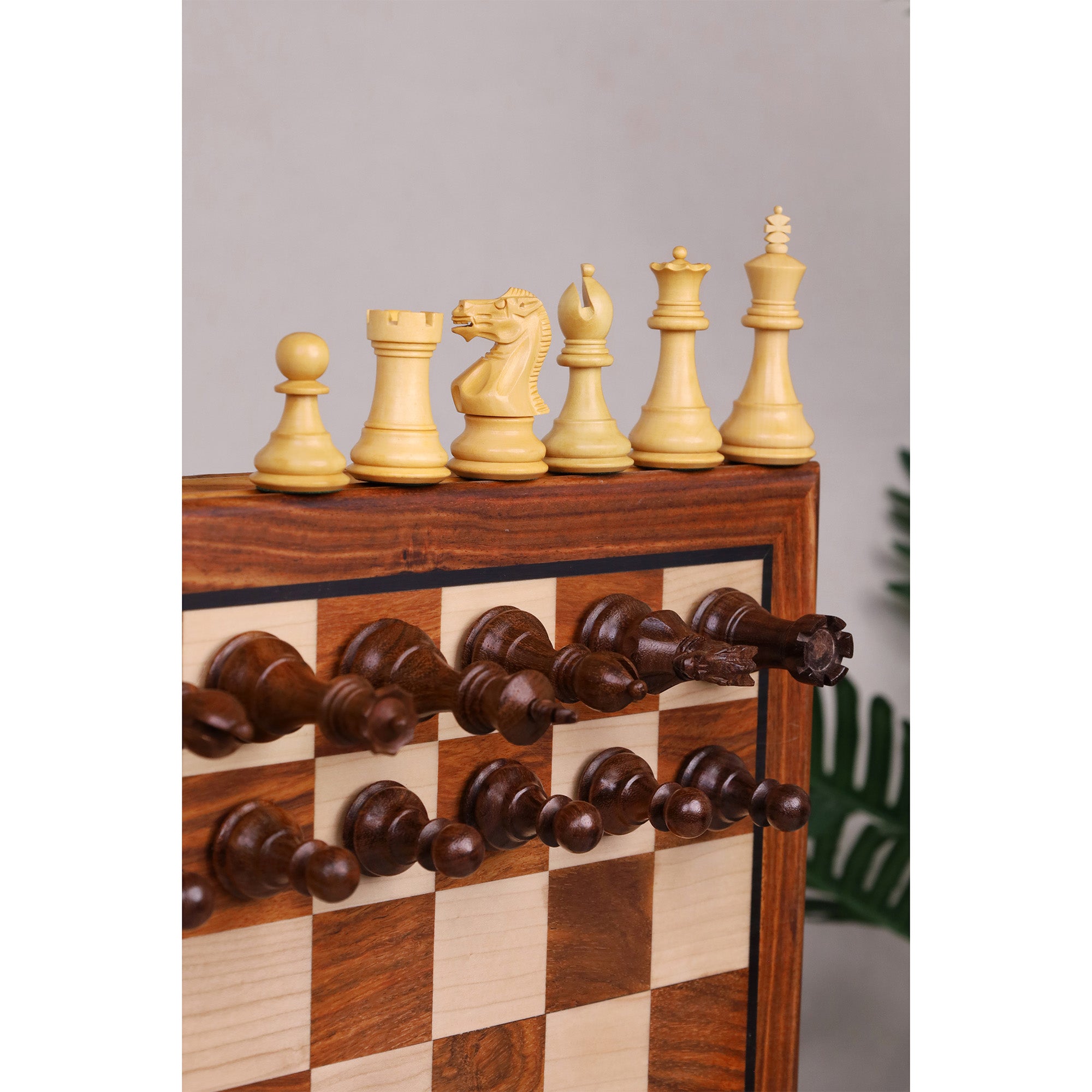 Close-up of finely carved wooden chess pieces on a luxury golden rosewood travel board.