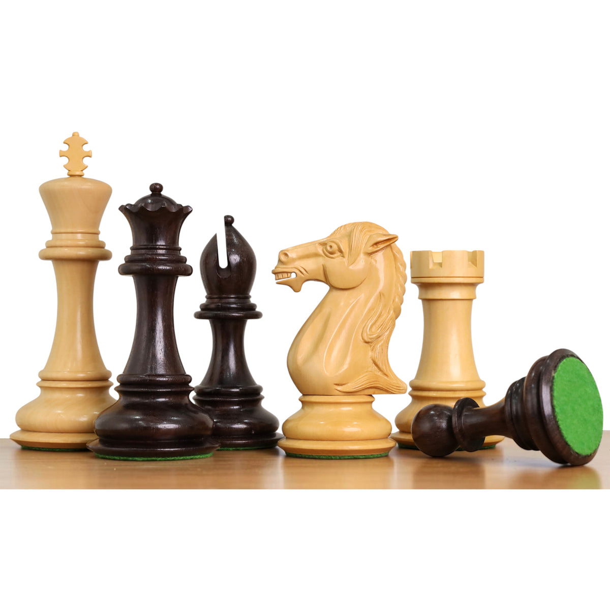 Lineup of weighted rosewood Staunton chess pieces showcasing detailed carving and green felt bases.