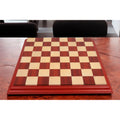 Large 23 inch professional wooden chessboard placed on a dark wood table in a luxury interior setting.