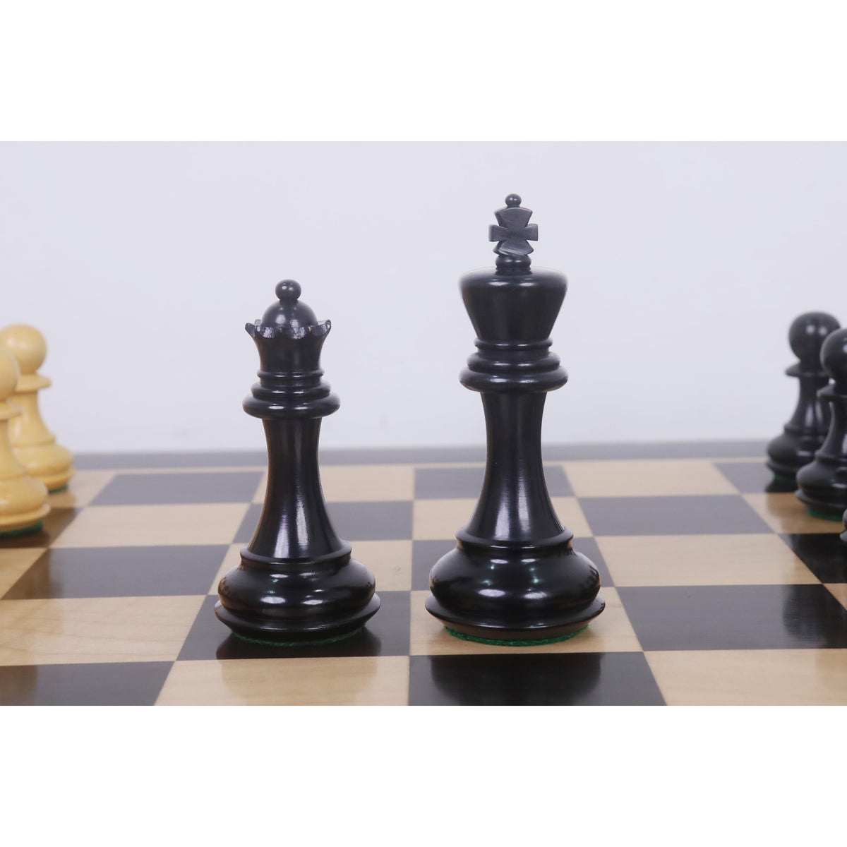 Standing Ebonised Pro Staunton King and Queen pieces on a wooden board.
