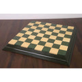 Full 21 inch green and maple wood chess board with decorative borders on a wooden table.