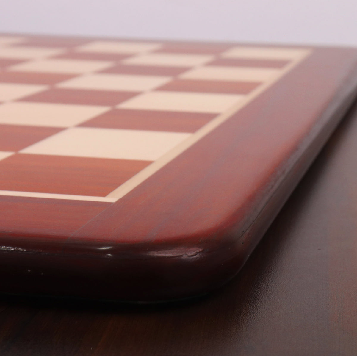 Side profile view showing the thickness and smooth polished edge of the luxury Bud Rosewood chess board.