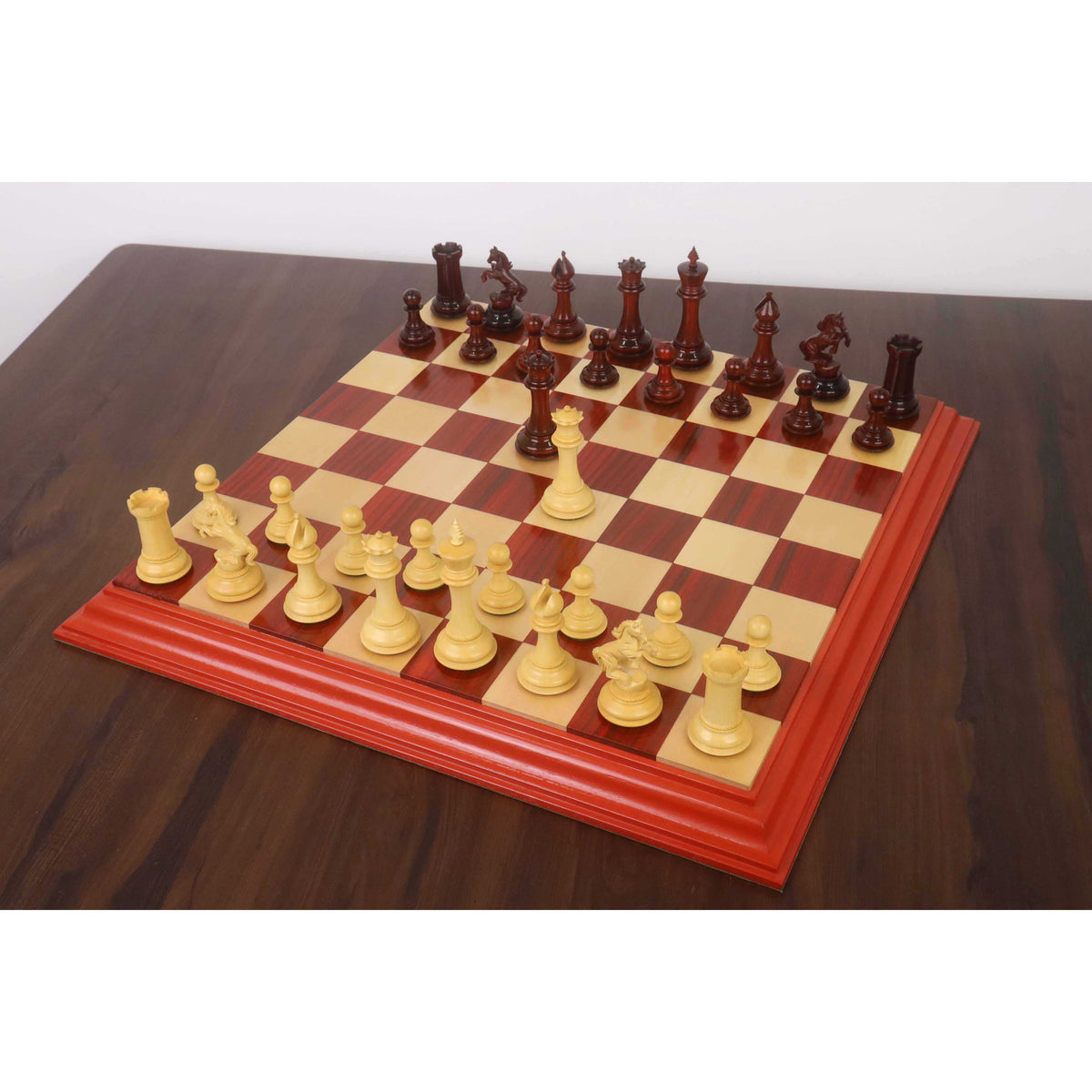 Full setup of the 4.5 inch Incitatus luxury Staunton chess set on a matching gloss-finish wooden chess board.