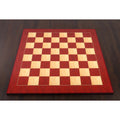 Full top-down perspective of a 21-inch Red Ash Burl & Burl Boxwood printed chess board on a dark wood table.