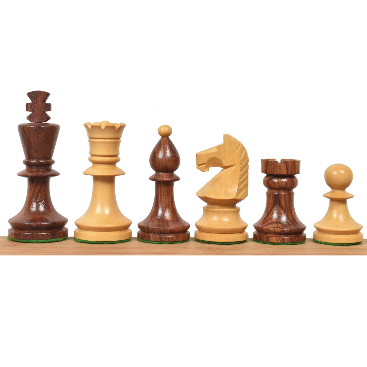 Romanian Hungarian chess pieces in golden rosewood and natural boxwood lined up on a wooden surface.