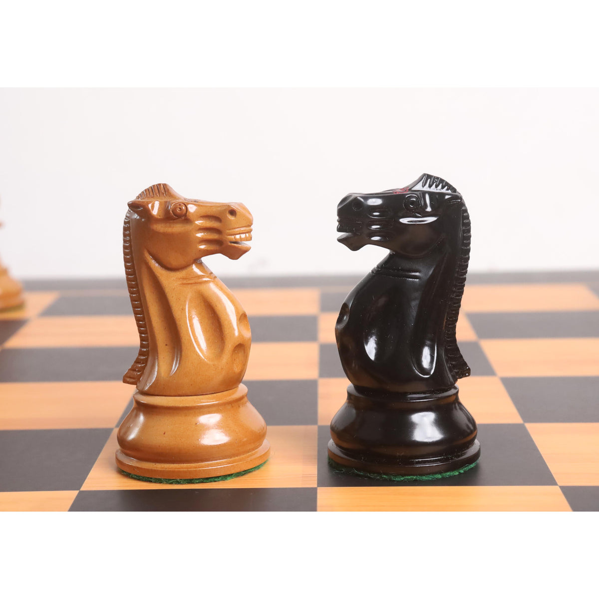 Close-up comparison of the intricately carved Ebony and Antiqued Boxwood Knights from the 3.9" Lessing Staunton Chess Set.