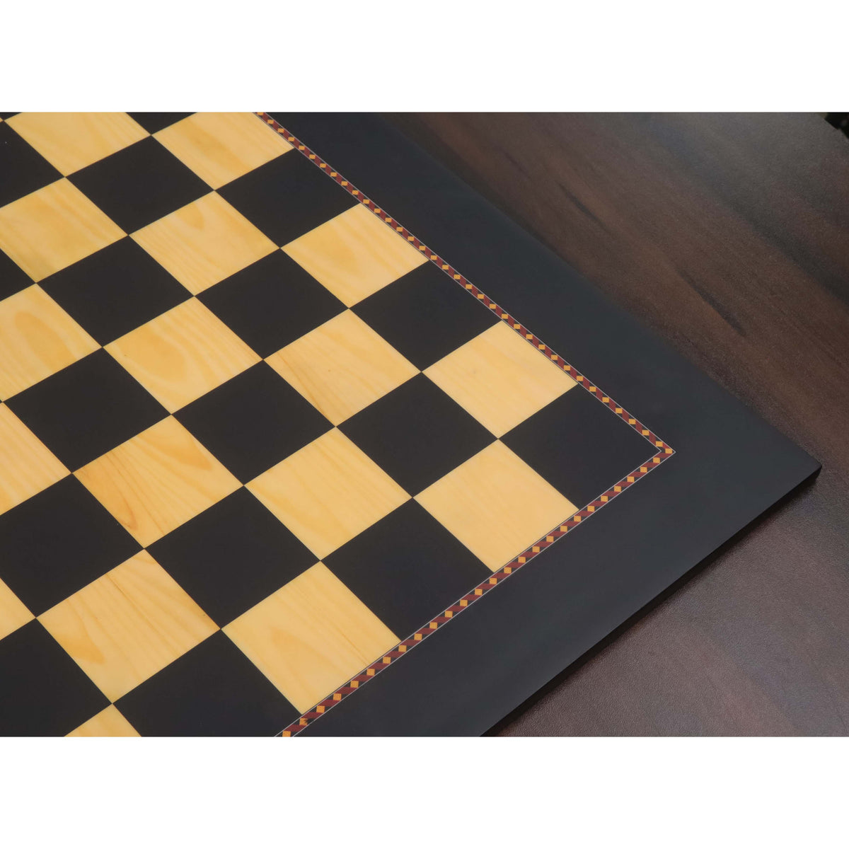 Detailed view of the decorative inlaid border on the Queens Gambit ebony and maple chess board.