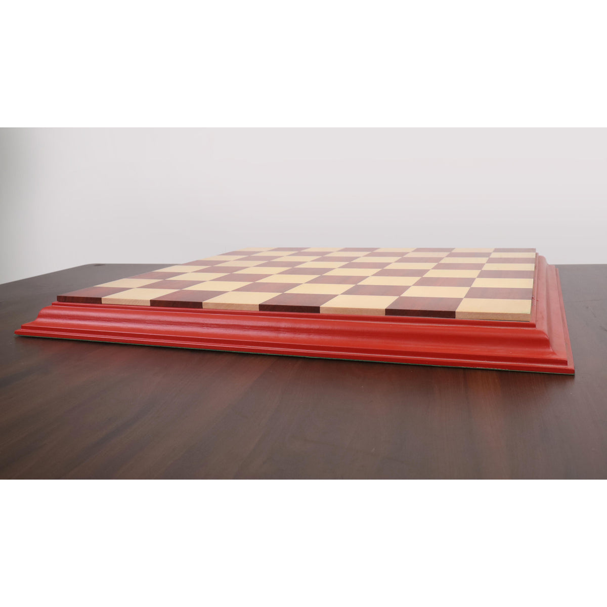 Side profile of a luxury Bud Rosewood chessboard showing the raised carved border and solid wood construction.