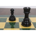 Close-up of ebony rook and pawn chess pieces on a printed chessboard.