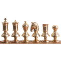 Metallic gold Victorian brass chess pieces arranged in a row from King to Pawn.