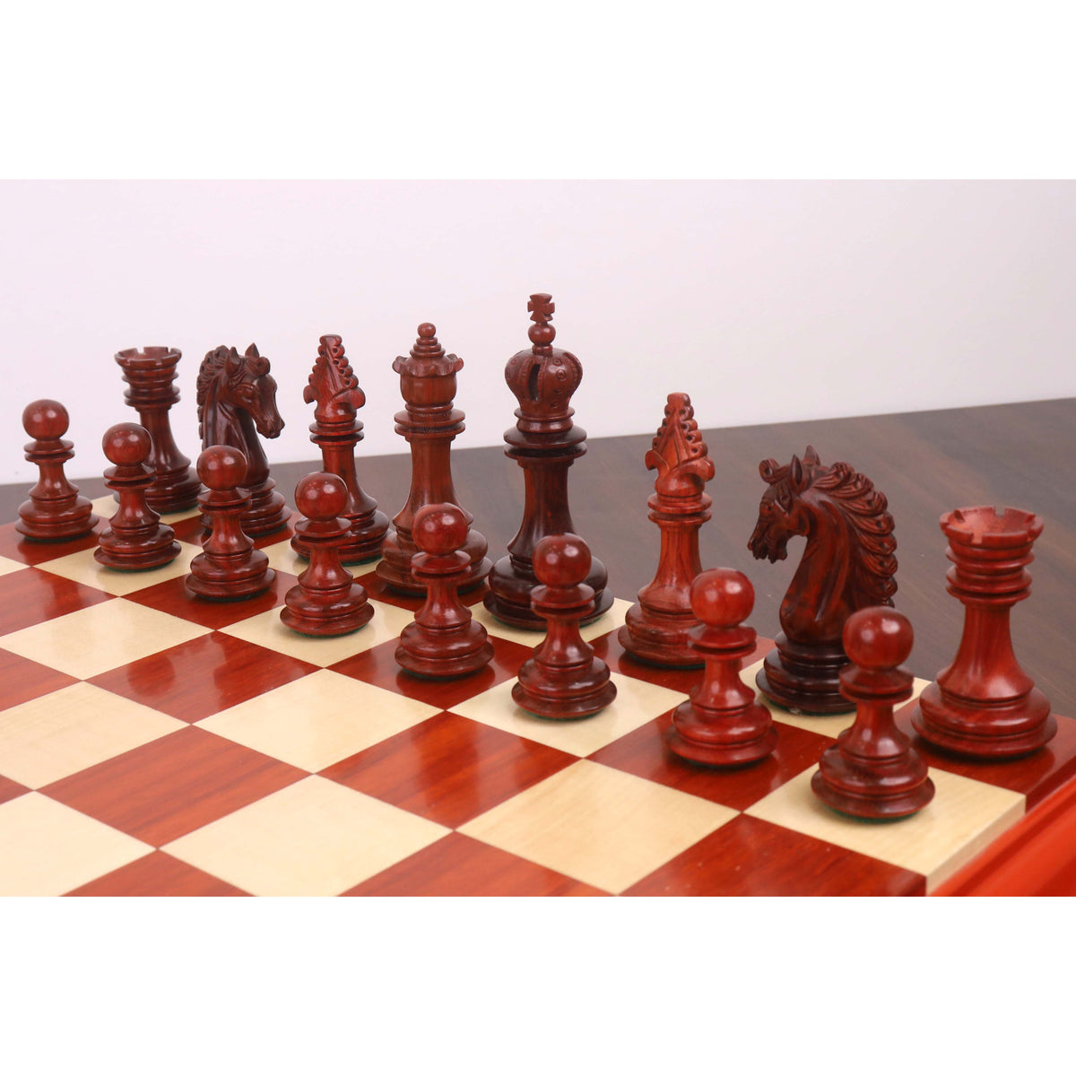 Intricately carved 4.5-inch budrose wood chess pieces on a luxury board.