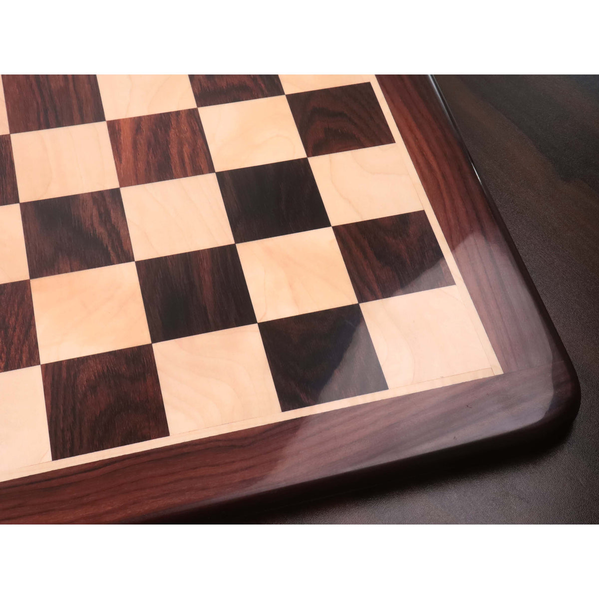 High-angle detail shot of the 25-inch rosewood chess board showing the polished finish, rounded corners, and 65 mm square dimensions.