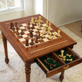 High-angle shot of the table with an open drawer holding scattered Golden Rosewood Staunton pieces.