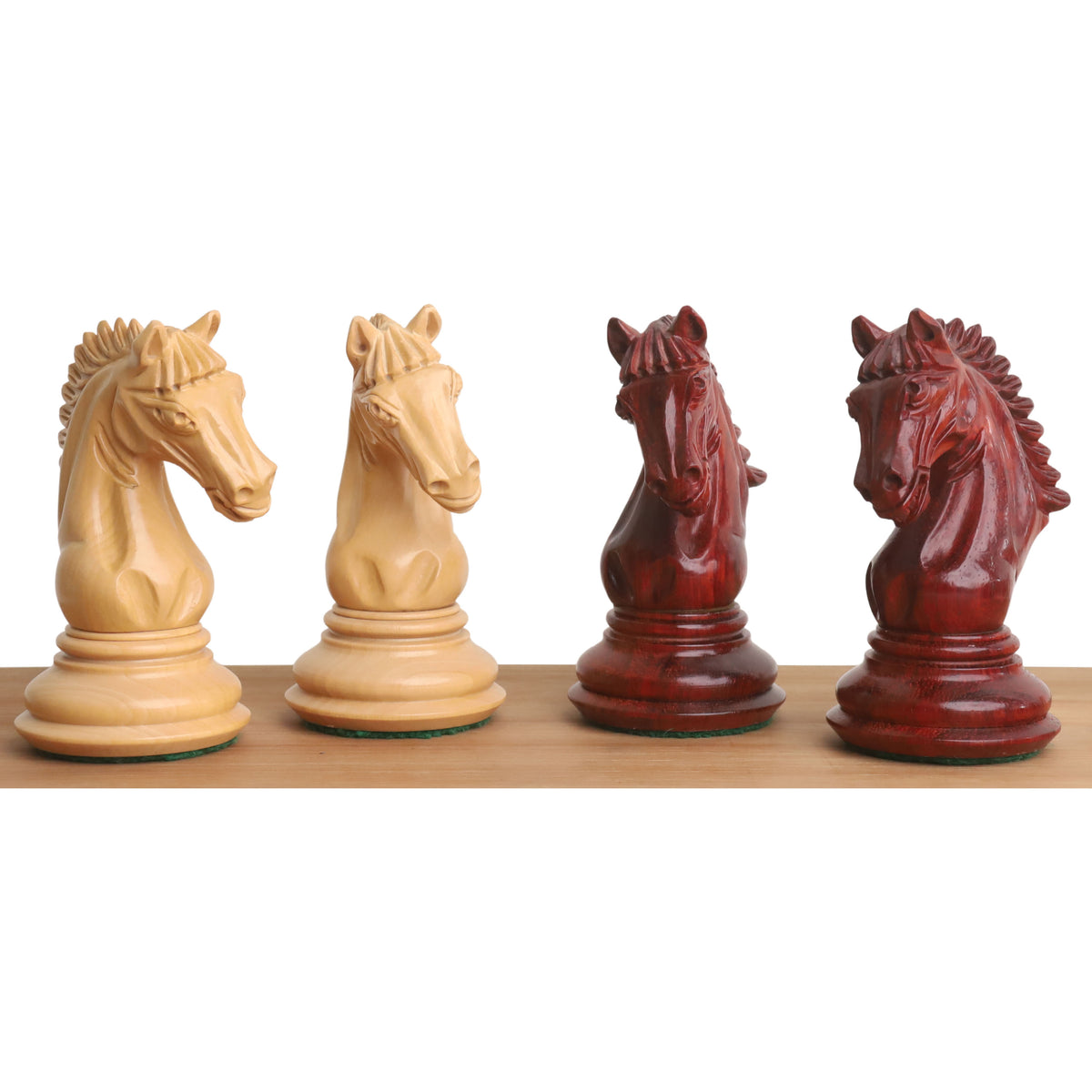 Detailed view of four hand-carved Bud Rosewood and Boxwood chess knights.