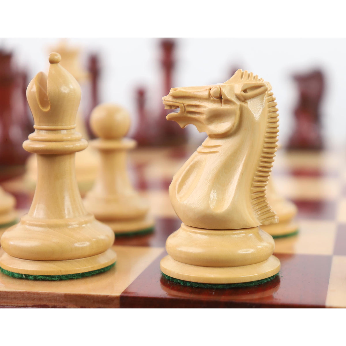 Light boxwood knight and bishop close up on wooden chessboard
