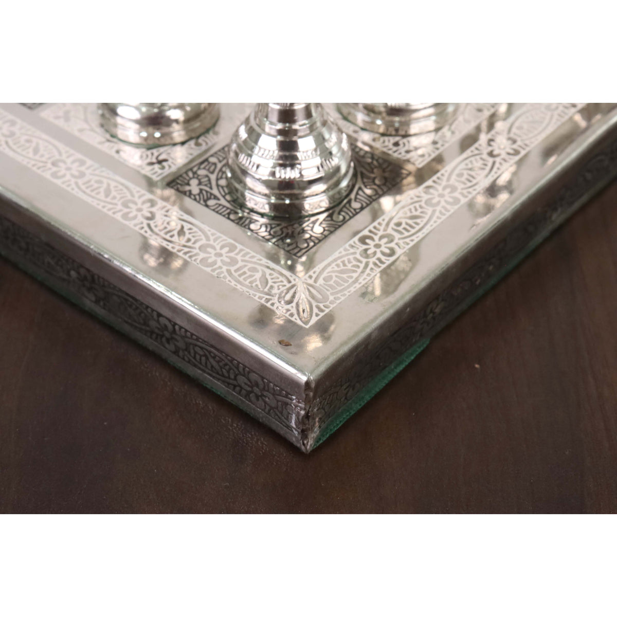 Close-up of the engraved floral corner border detail on the 12-inch luxury brass metal chess board.