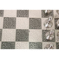 Top-down view of the decorative black and silver alternating pattern squares on the unique metal chess board.