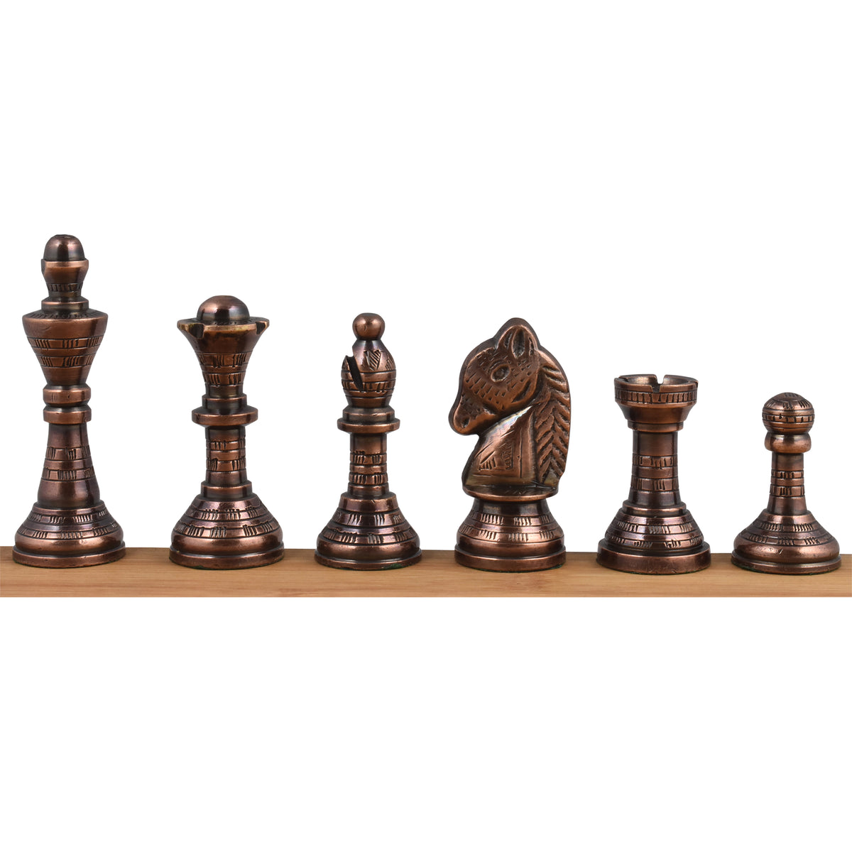 A lineup of the copper brass chess pieces (king, queen, bishop, knight, rook, pawn) on a wooden display.