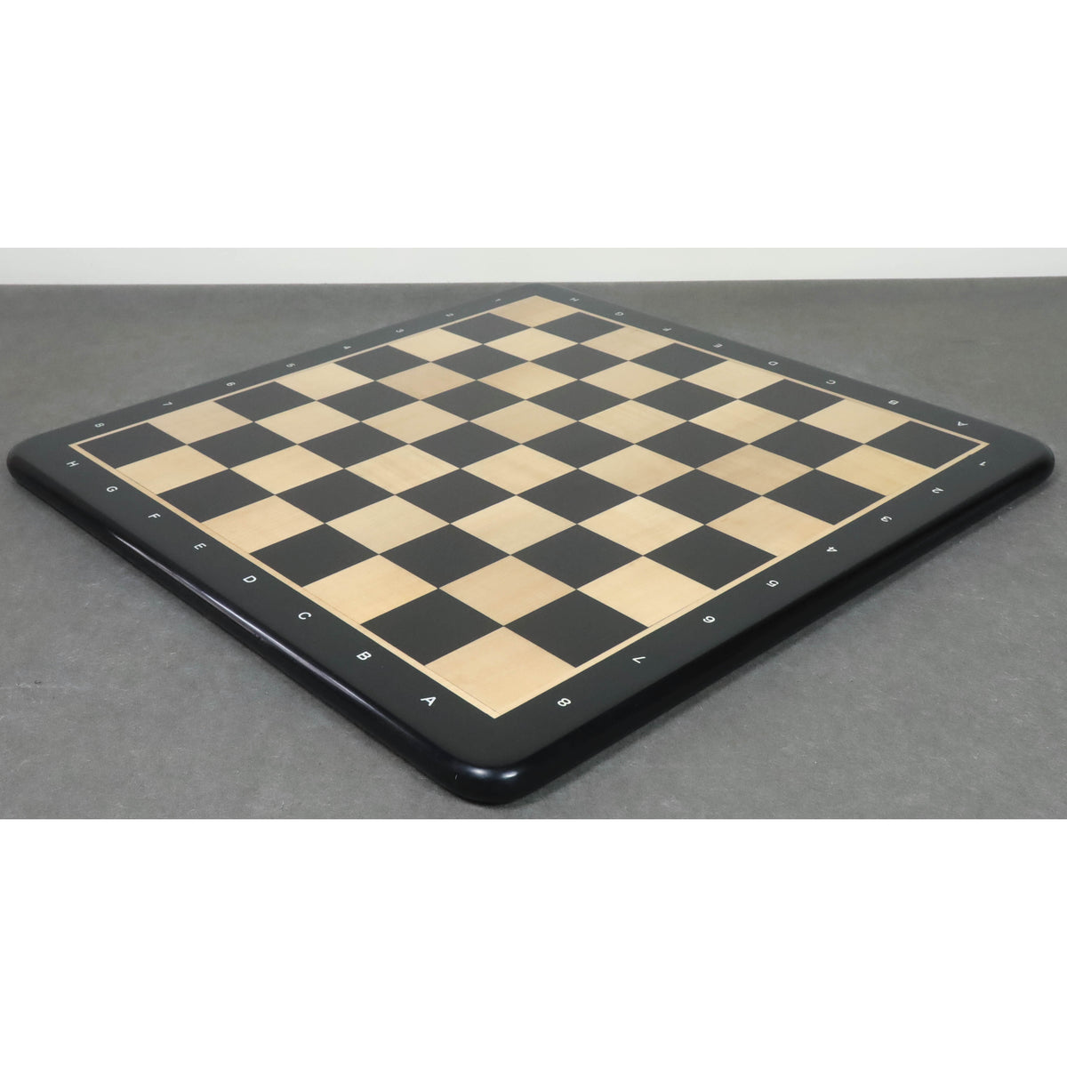 Diagonal perspective of a 21-inch ebony wood and maple wood chess board.
