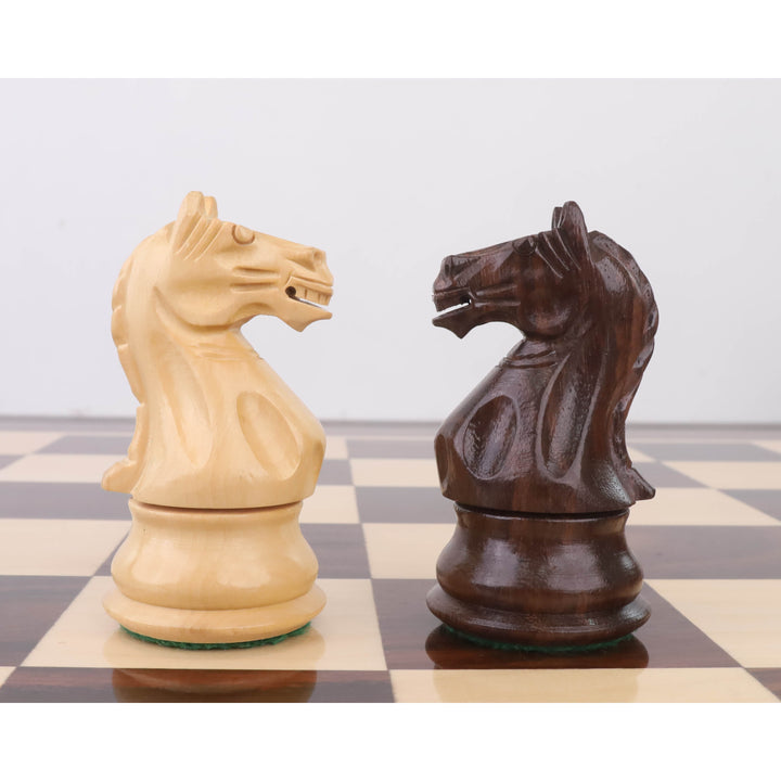 Close-up of handcrafted rosewood and boxwood Fierce Knight chess pieces facing each other.