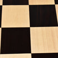 Close-up texture shot of a wooden chessboard highlighting the natural wood grain on the squares.