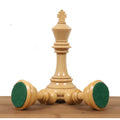 Triple weighted boxwood chess pieces displaying their green felt-lined bases.