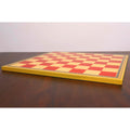 Slim profile view of a 20-inch Leuchars wooden chess board resting flat on a wooden table.