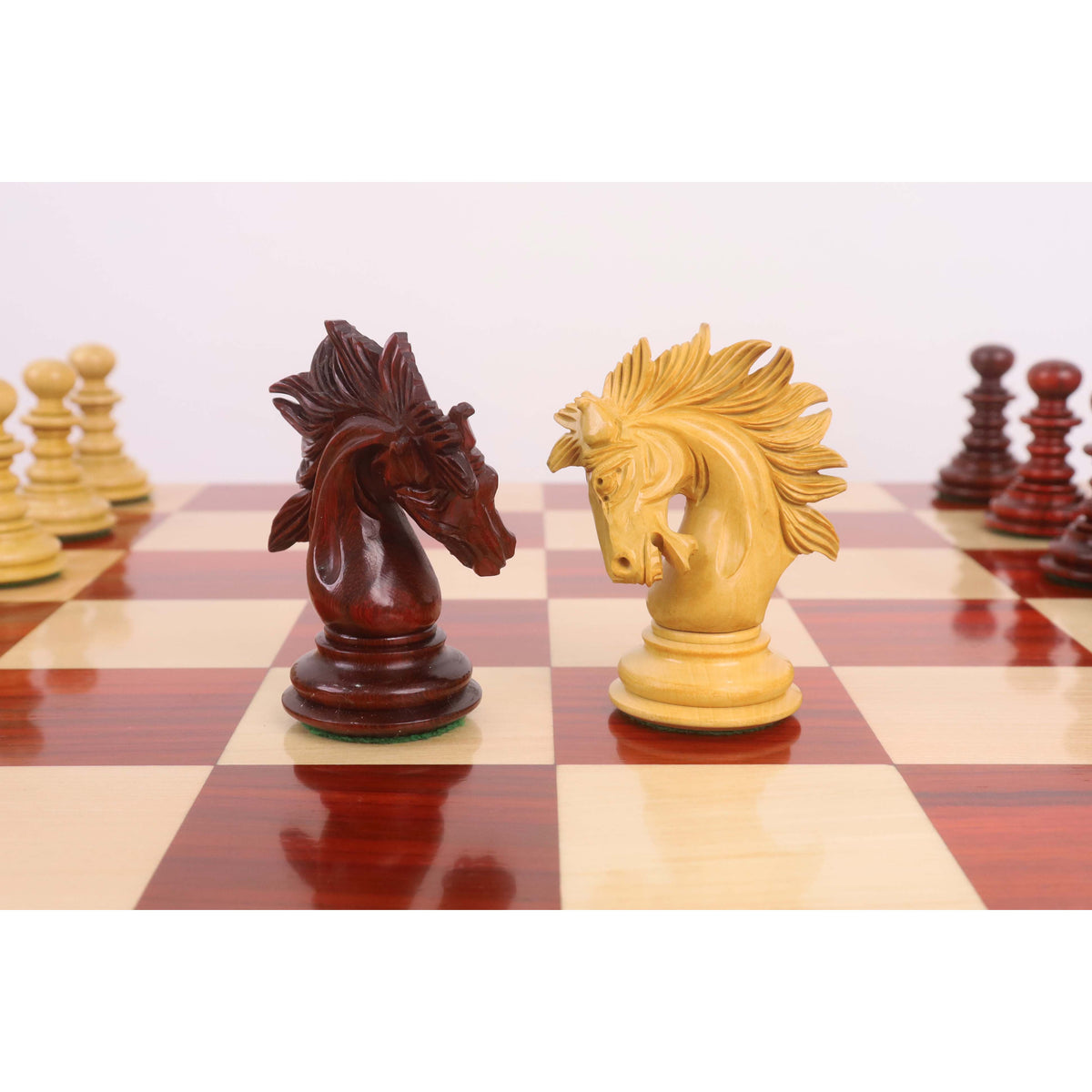 Close-up side view of wooden Staunton knight chess pieces.