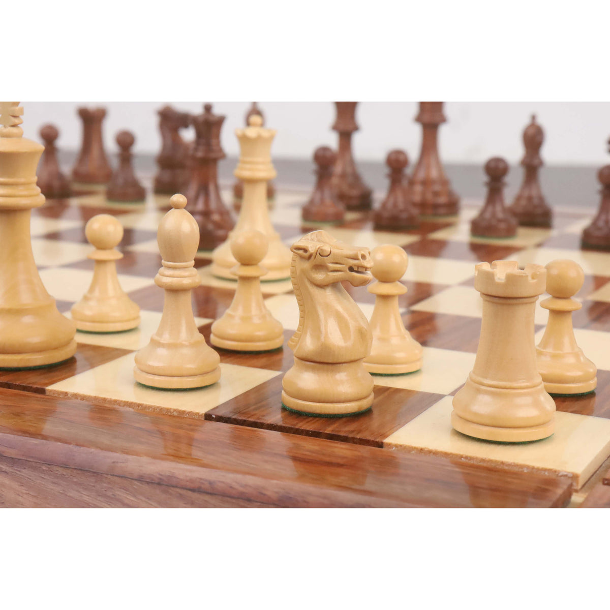 Detailed view of handcrafted Boxwood Knight and Rook pieces on a professional wooden chessboard.