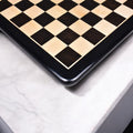 Angled view showing the smooth finish and dark border of a 19-inch wooden chess board.