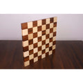 Borderless end grain chess board standing vertically to display its thick solid wood profile.