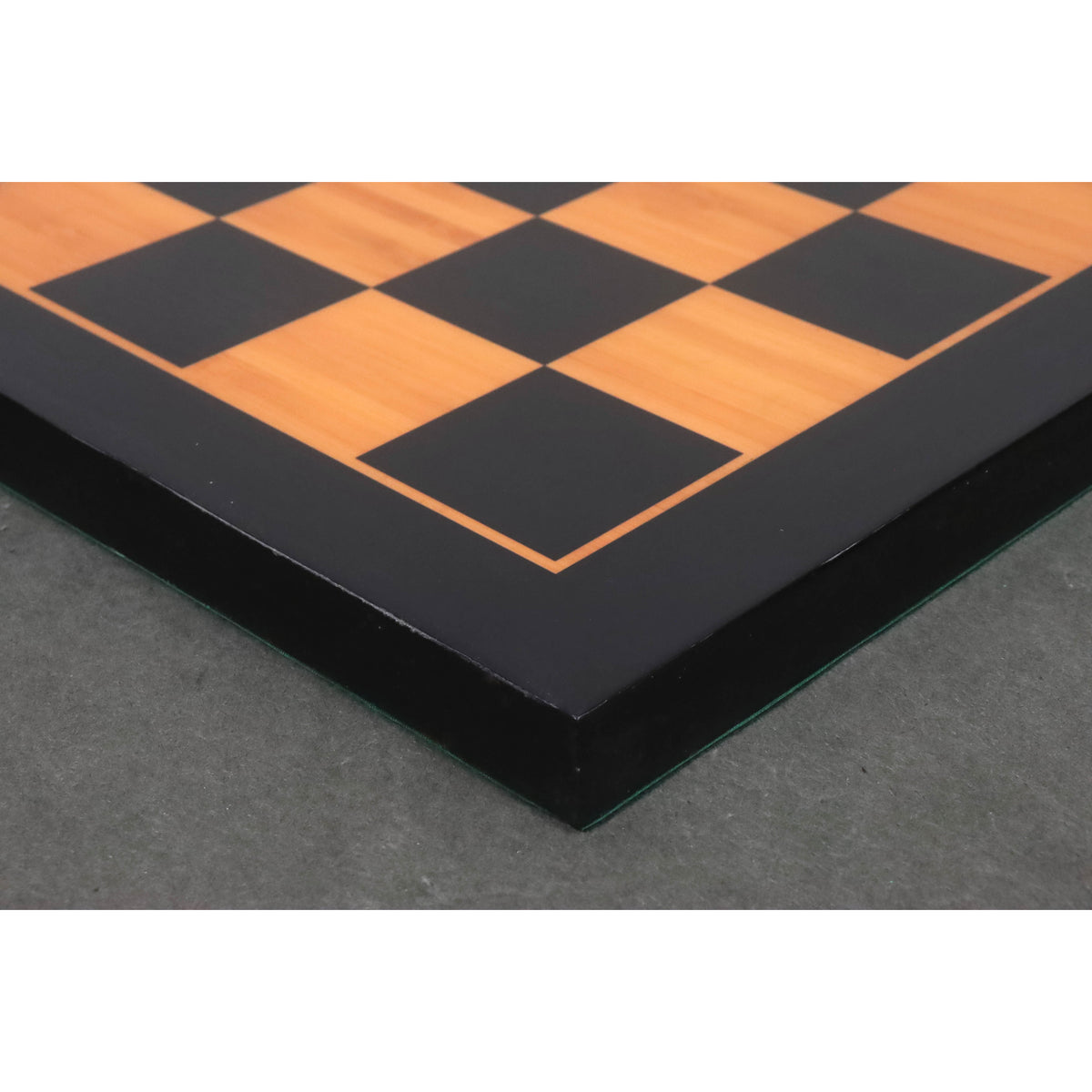 Corner detail of a professional 21 inch wooden chess board showing the 55mm square size and ebony border.