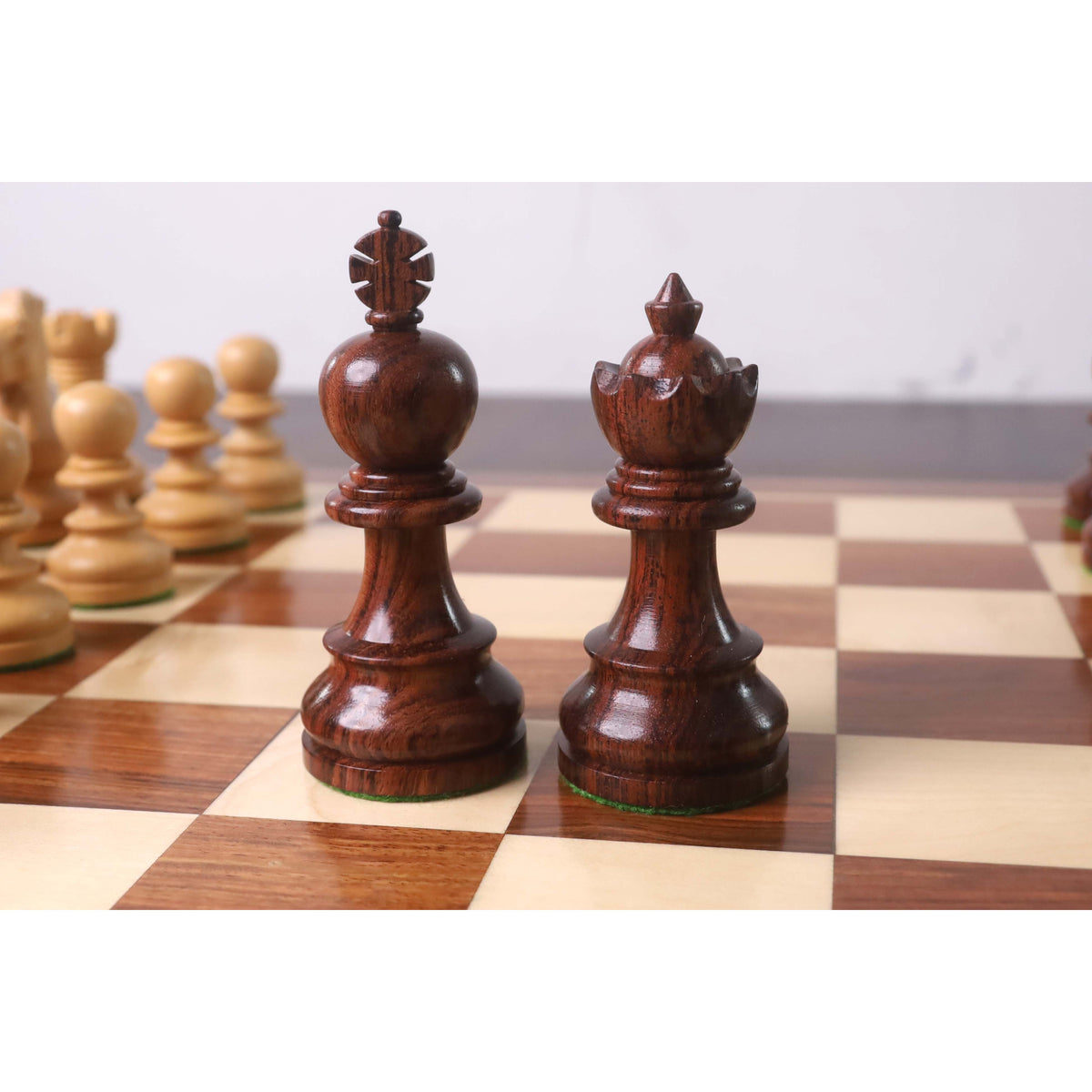 Close-up of the elegant rosewood Taj Mahal Staunton King and Queen pieces on a chessboard.