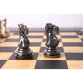 Gold and grey brass chess knights face-off.