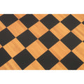 Top-down macro view of the 55mm chess squares showing the natural grain texture of the antique boxwood and ebony printed design.