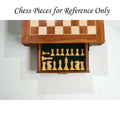 Interior of the chess table drawer with green felt lining, storing a complete set of light-colored wood chess pieces.