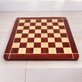 A 23" Bud Rosewood and Maple wooden chessboard, viewed from a high angle, displays empty squares and a smooth finish.