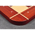 Macro detail of the rounded corner and smooth finish of a Bud Rosewood chess board with inlaid Maple border.