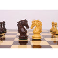 Close-up of intricately carved Rosewood and Boxwood Knight pieces from the 3.9" Heritage Series Staunton set facing each other on a chessboard.