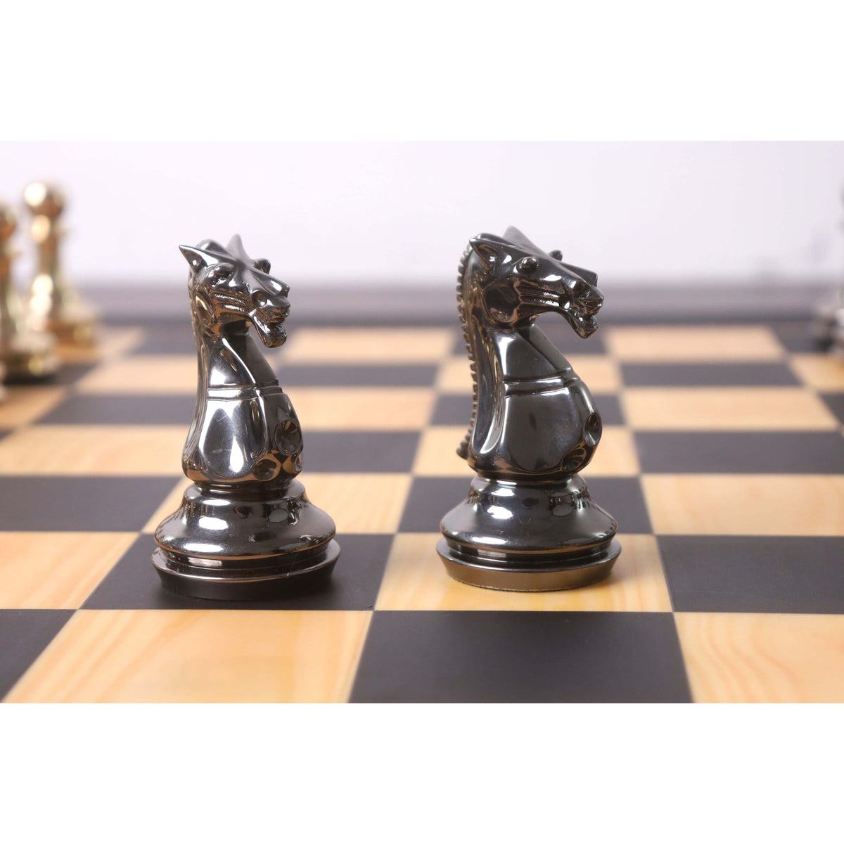 Gold and grey brass chess knights face-off.