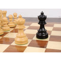 White Queen and black Bishop from the Taj Mahal ebonised chess set positioned on a wooden board.