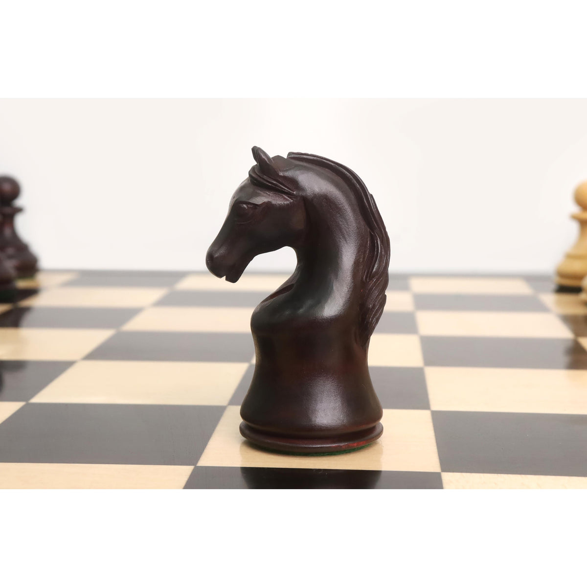 A close-up profile of a finely carved mahogany-stained Piatigorsky Cup chess knight.